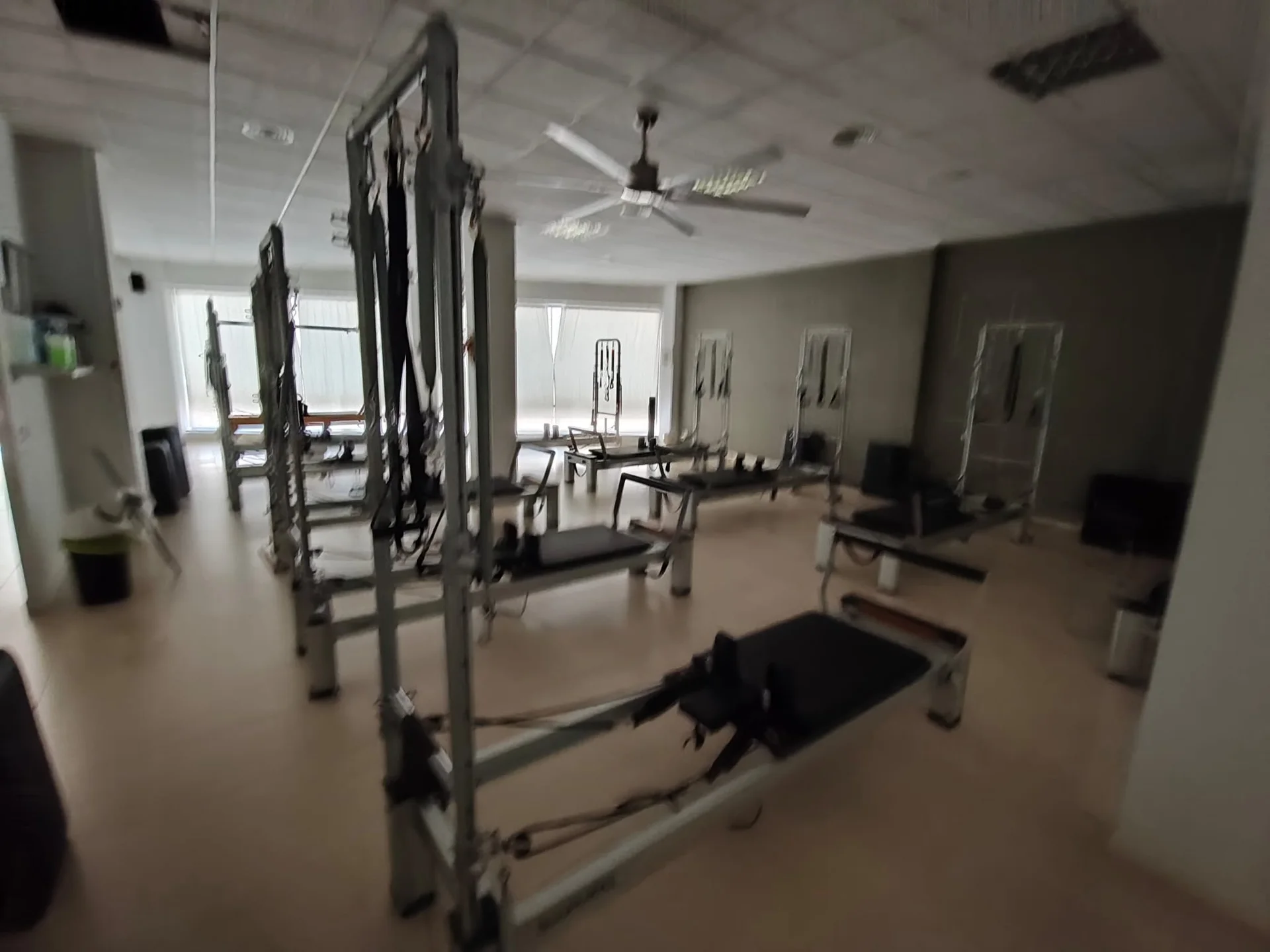 Sala de mi'a pilates studio en Totana: una torre cadillac en primer plano y una fila de reformers al fondo